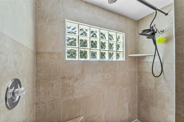 a bathroom with a granite countertop shower and a window