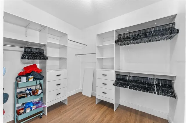 a view of walk in closet with clothes and shoes