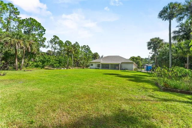 a view of a green field with wooden fence
