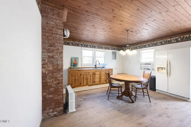a dining room with furniture and a wooden floor