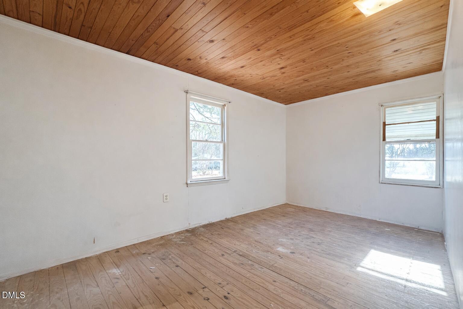 829 Shaw's Pond Road Four Oaks, NC 27524 - Photo 13 of 30 an empty room with wooden floor and windows