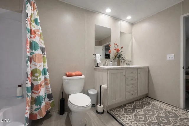 a bathroom with a sink mirror vanity and toilet