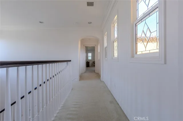 a view of a hallway with wooden floor and windows