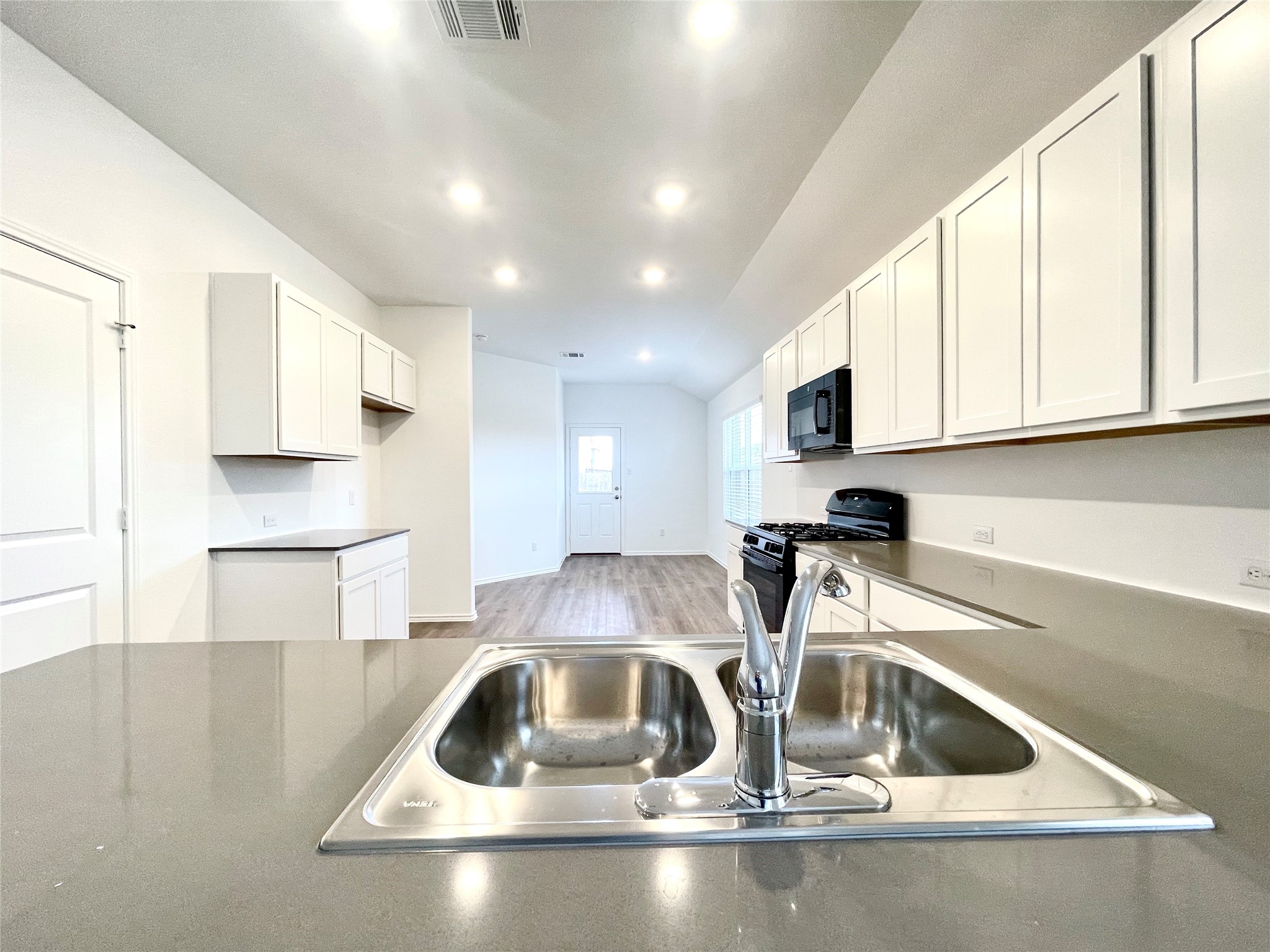 305 Milliner Loop Hutto, TX 78634 - Photo 12 of 36 a kitchen with a sink a microwave and cabinets