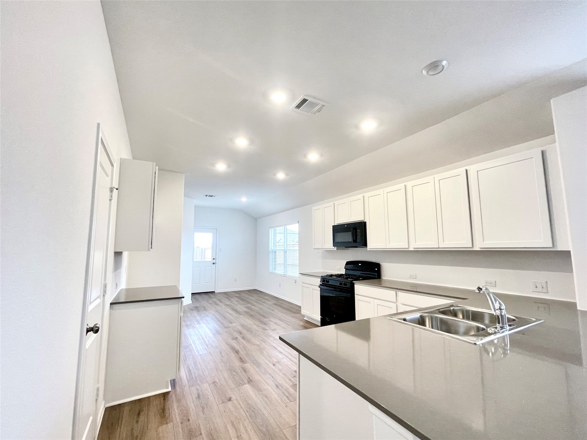 305 Milliner Loop Hutto, TX 78634 - Photo 15 of 36 a kitchen with kitchen island a counter top space a sink stainless steel appliances and cabinets