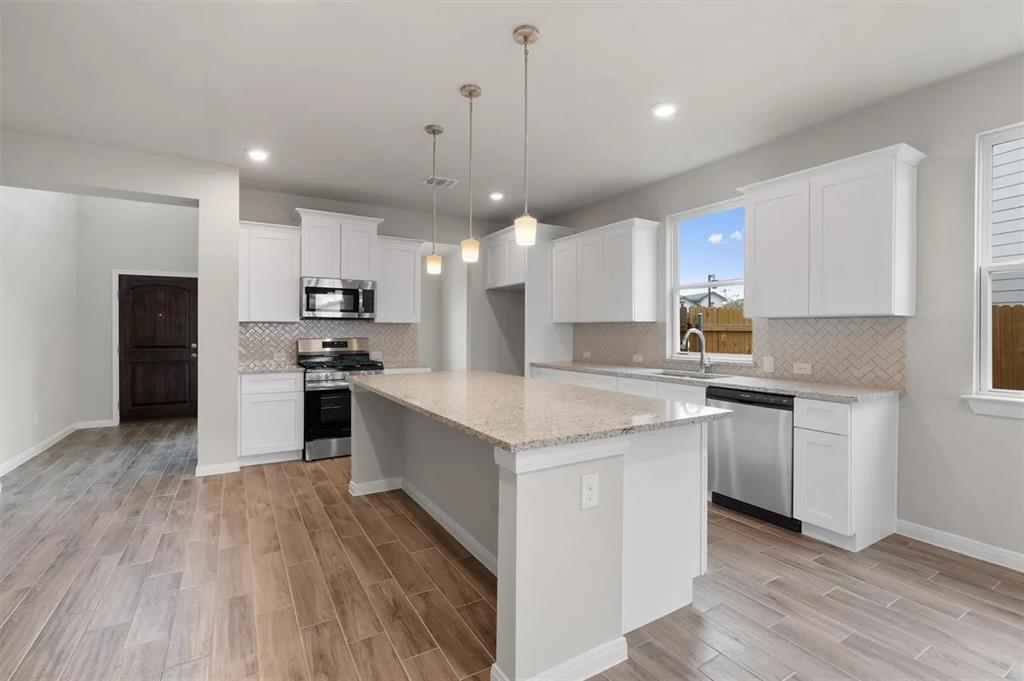 332 Stellar Wind Drive Georgetown, TX 78628 - Photo 8 of 29 Culinary delights await in this bright kitchen, complete with an expansive island and sophisticated finishes.