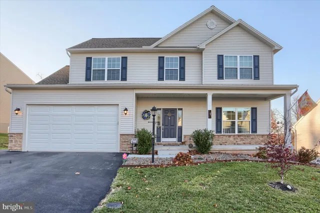 a front view of a house with a garden and plants