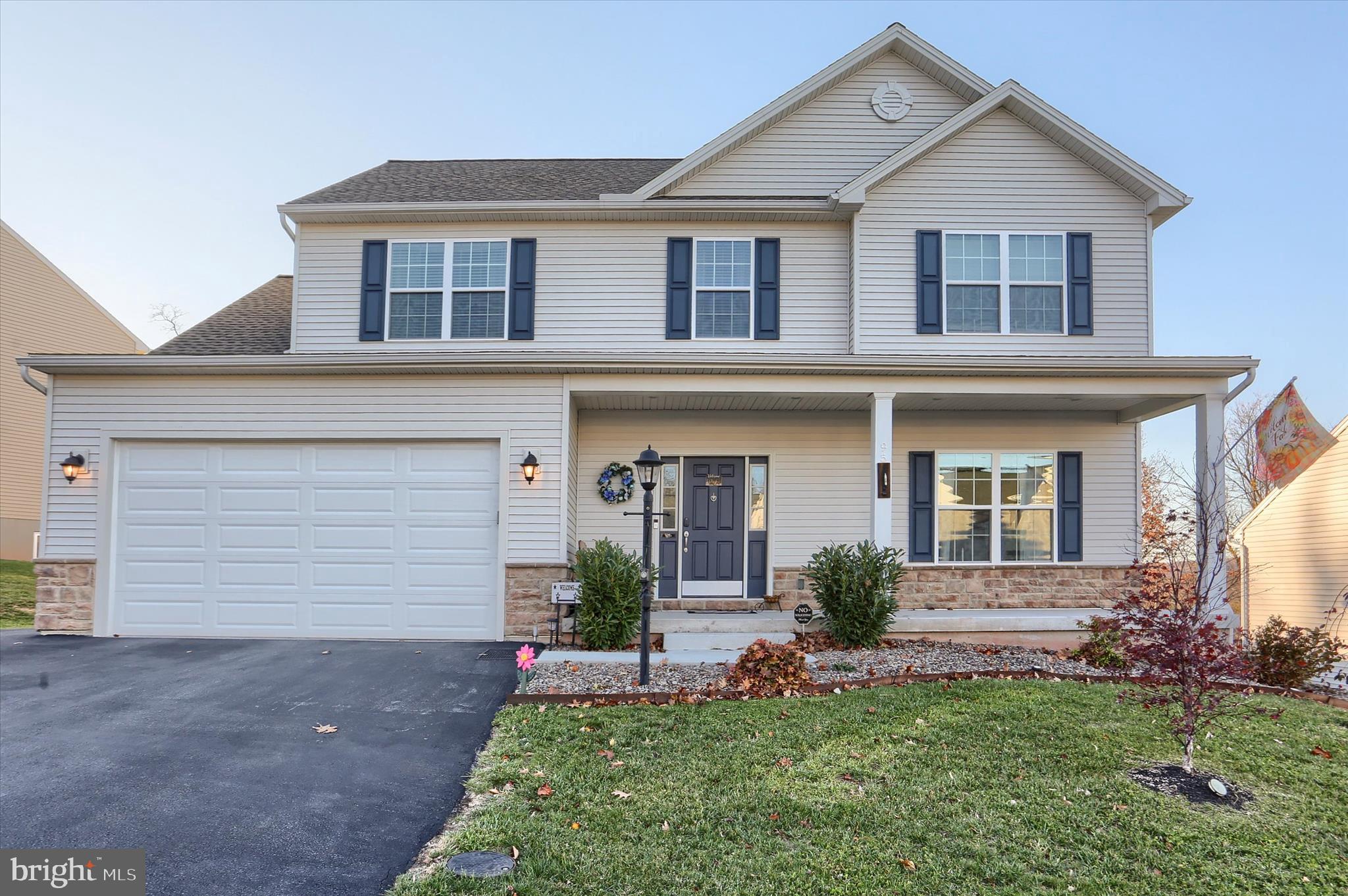 a front view of a house with a garden and plants