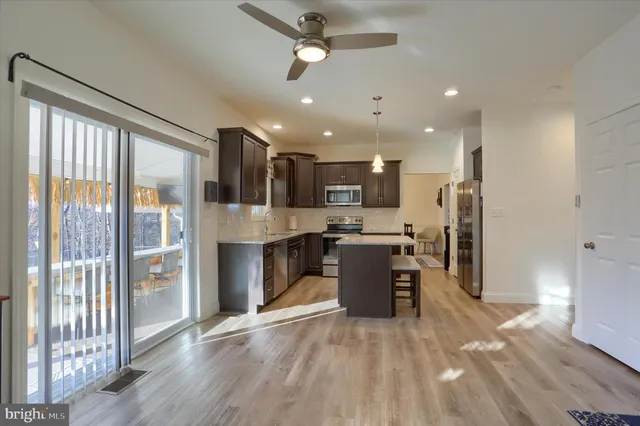 a living room with furniture a flat screen tv and a floor to ceiling window