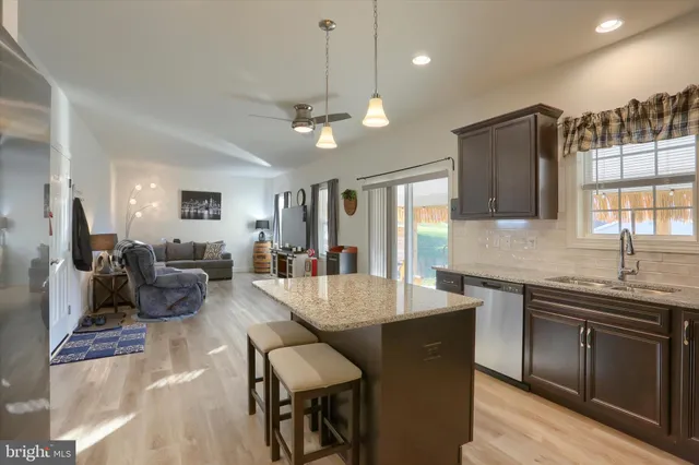 a kitchen with granite countertop kitchen island stainless steel appliances a stove sink microwave and cabinets