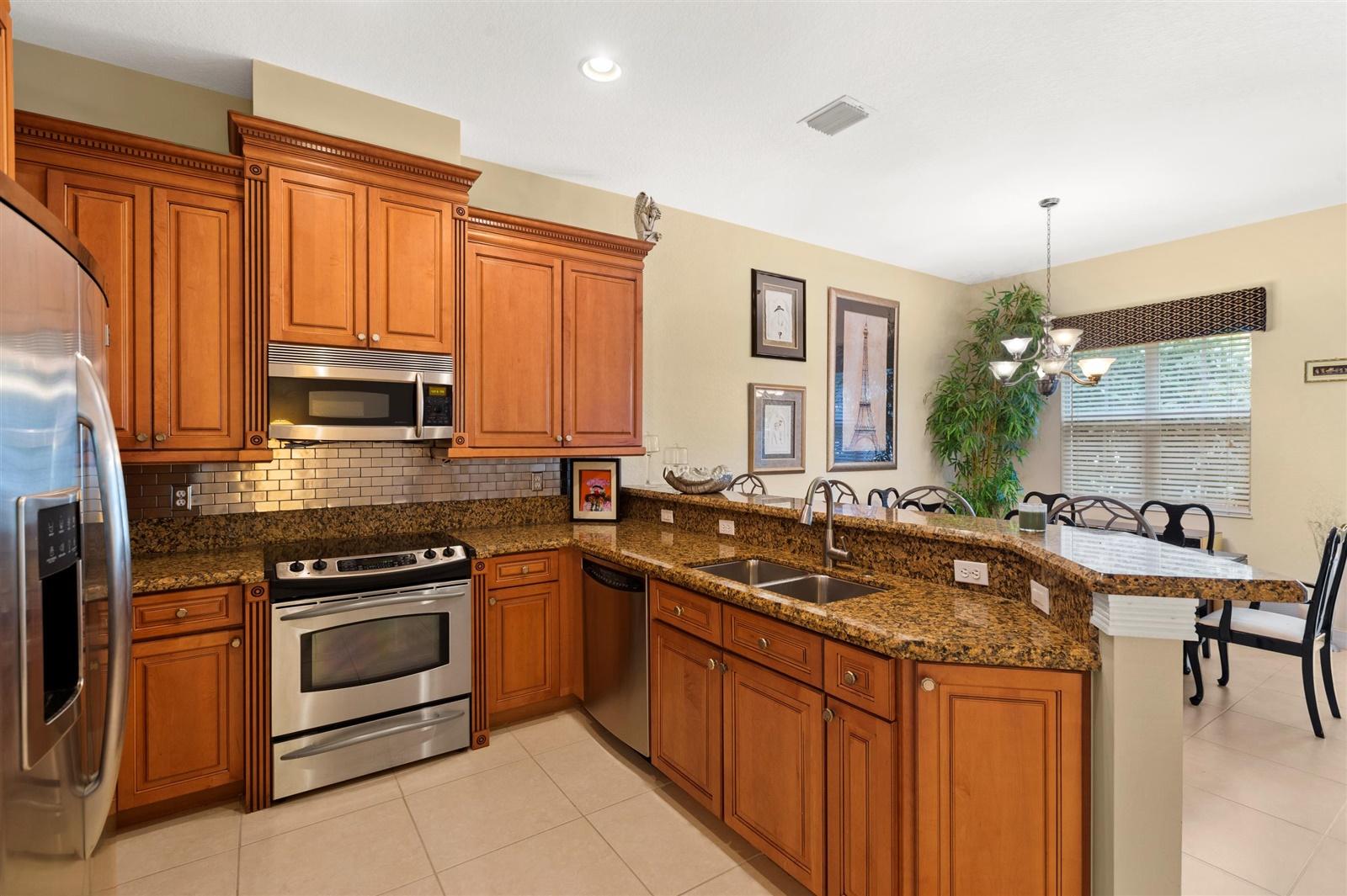 1000 North Us Highway, Unit 809 Jupiter, FL 33477 - Photo 10 of 30 a kitchen with granite countertop a sink stove and cabinets