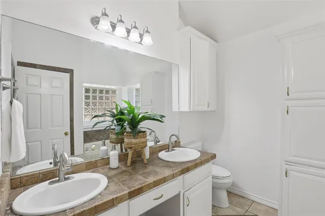 a bathroom with a granite countertop sink a toilet and mirror