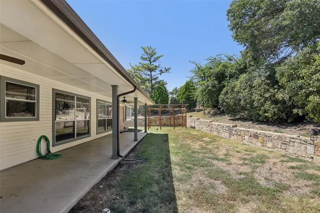 a view of a house with backyard and sitting area