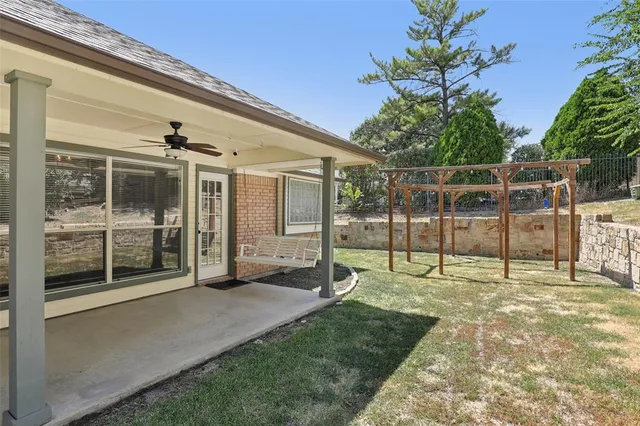 a view of a backyard with floor to ceiling window and plants