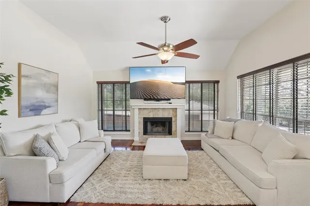 a living room with furniture a fireplace and a large window