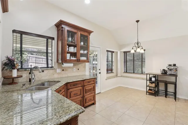 a spacious bathroom with a granite countertop sink and a bathtub