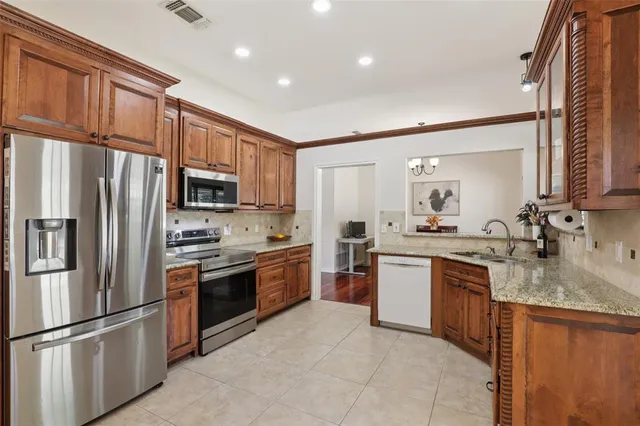 a kitchen with stainless steel appliances granite countertop a refrigerator stove microwave and sink