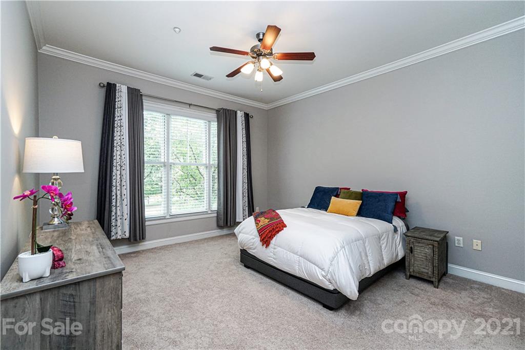 5425 Closeburn Road, Unit 103 Charlotte, NC 28210 - Photo 17 of 39 a bedroom with bed and a chandelier