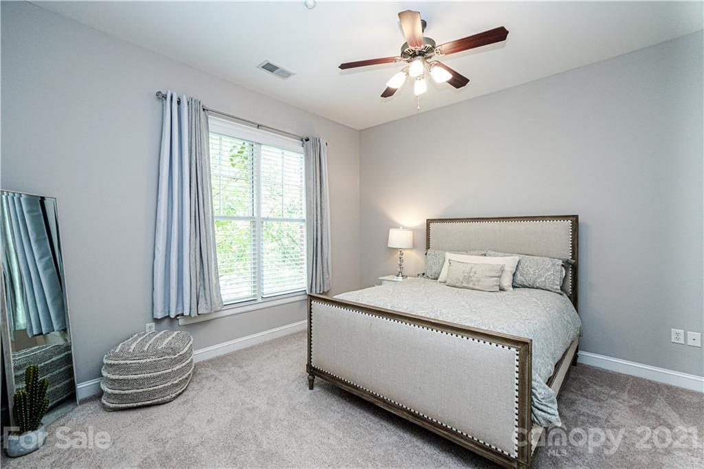 5425 Closeburn Road, Unit 103 Charlotte, NC 28210 - Photo 23 of 39 a bedroom with a bed and a chandelier