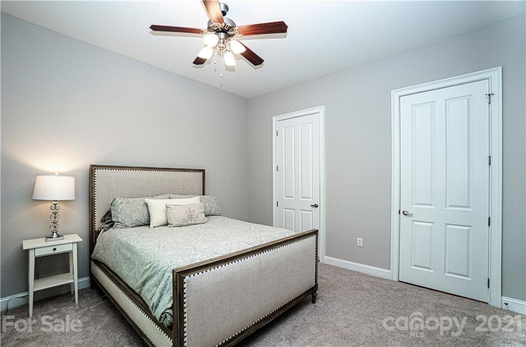 5425 Closeburn Road, Unit 103 Charlotte, NC 28210 - Photo 24 of 39 a bedroom with a bed and a chandelier
