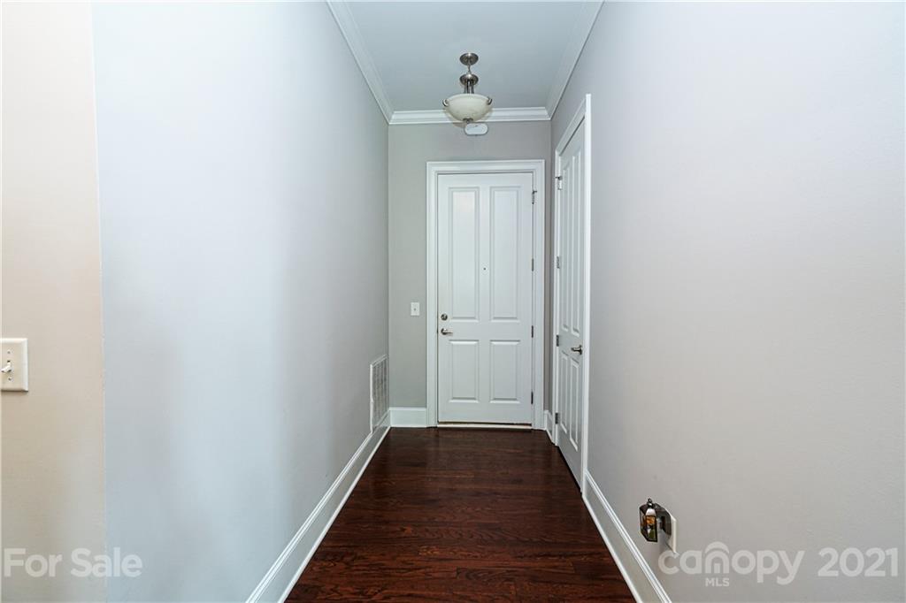 5425 Closeburn Road, Unit 103 Charlotte, NC 28210 - Photo 30 of 39 a view of a hallway with wooden floor and a chandelier