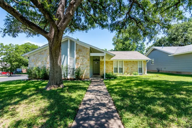 a view of a house with a yard and tree s