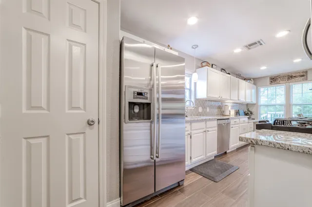 a kitchen with a refrigerator and white cabinets