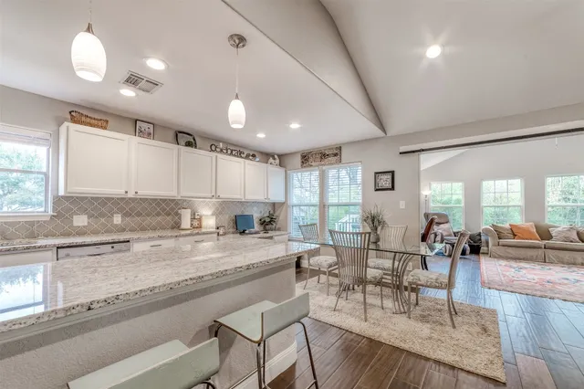 a large open kitchen with a large window and stainless steel appliances