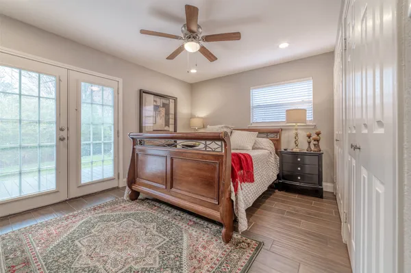 a bedroom with a bed a dresser next to a window