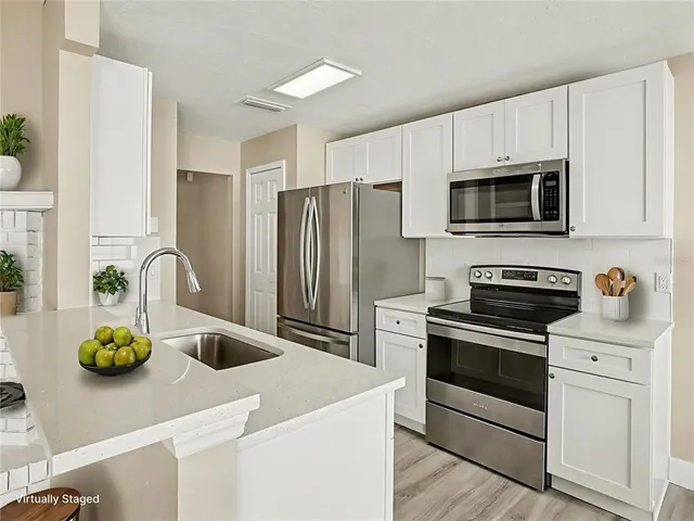 a view of a kitchen with an empty space wooden floor and a kitchen