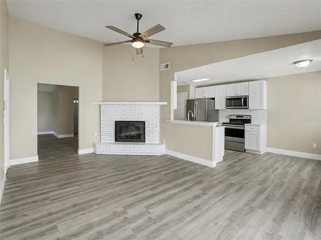 a view of an empty room with wooden floor