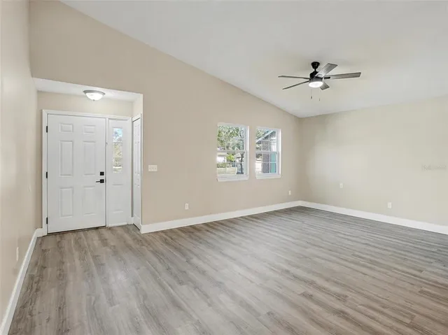 a view of an empty room with wooden floor