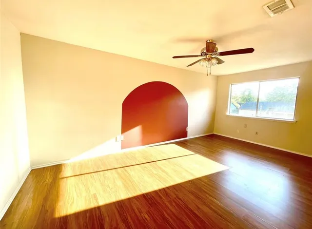 a view of a room with wooden floor and a window