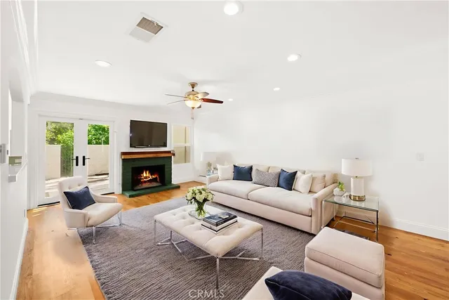 a view of an empty room with wooden floor and a fireplace