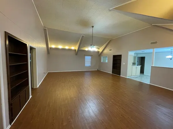 a view of a room with wooden floor and a ceiling fan