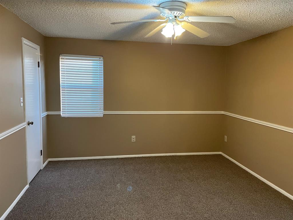 11888 Fm Road Seymour, TX 76380 - Photo 7 of 14 an empty room with a window and a fan