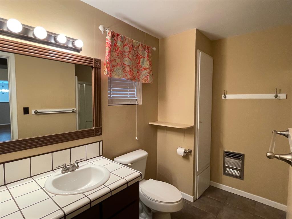 11888 Fm Road Seymour, TX 76380 - Photo 9 of 14 a bathroom with a sink a toilet a mirror and shower