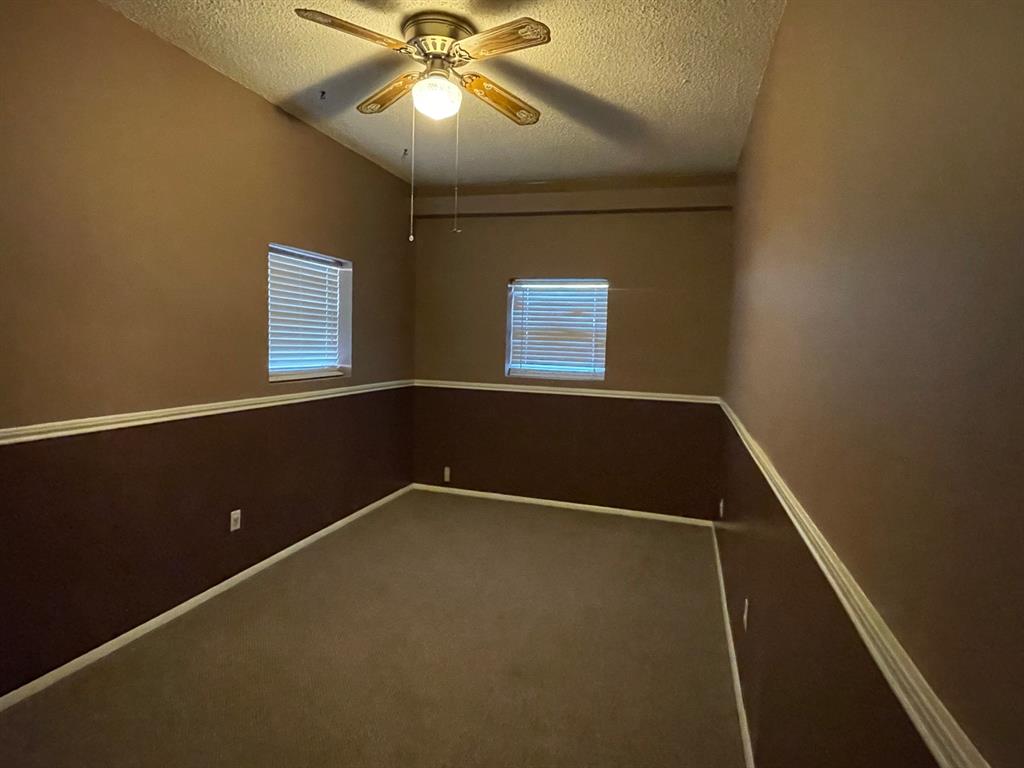 11888 Fm Road Seymour, TX 76380 - Photo 10 of 14 an empty room with a window and a ceiling fan