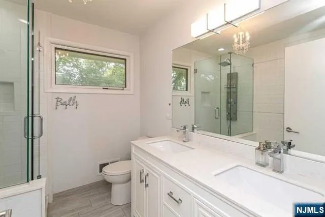 a bathroom with a sink a toilet and shower