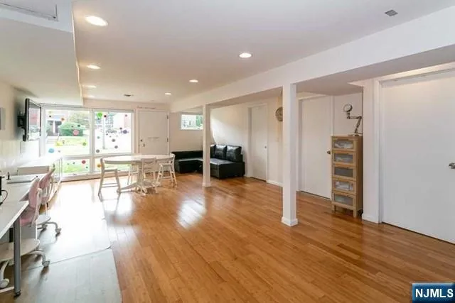a view of a living room kitchen with stainless steel appliances wooden floor dining table and chair
