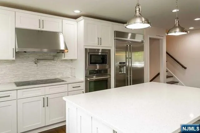 a kitchen with stainless steel appliances a refrigerator sink and microwave