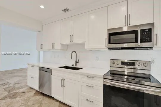 a kitchen with stainless steel appliances a stove microwave and cabinets