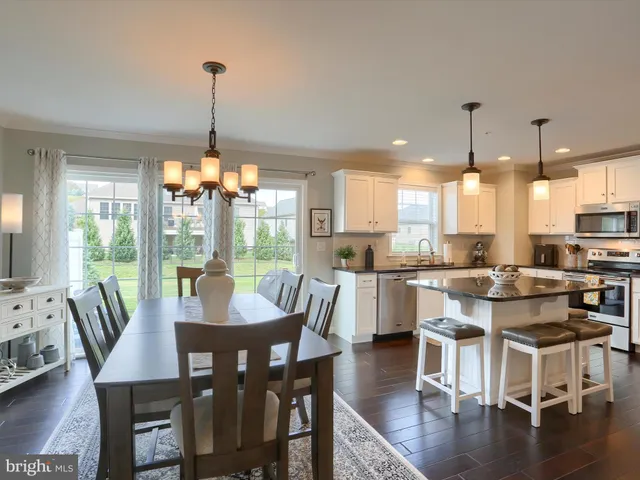 a view of a dining room and livingroom with furniture wooden floor a chandelier