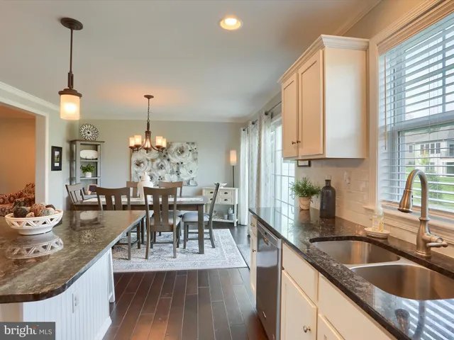 a kitchen with sink refrigerator dining table and chairs