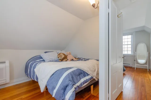 a bedroom with a bed and wooden floor