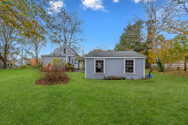 a view of a yard in front of a house with plants and large tree
