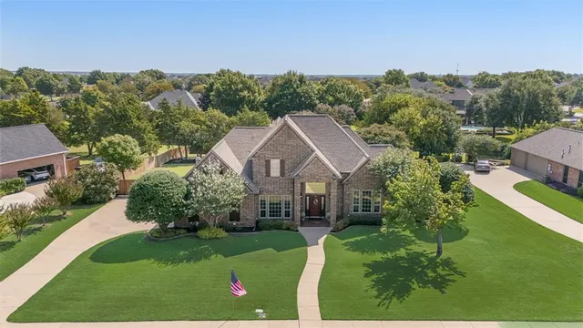 a view of a house with a big yard plants and large trees