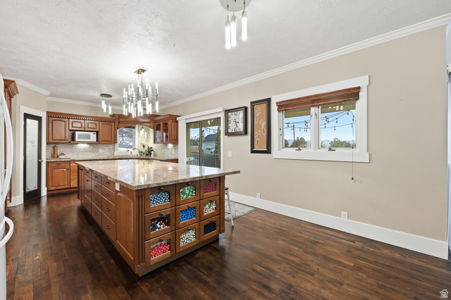 2342 Charros Road Sandy, UT 84092 - Photo 19 of 94 Kitchen featuring a large central island with a stone-finish countertop and integrated storage