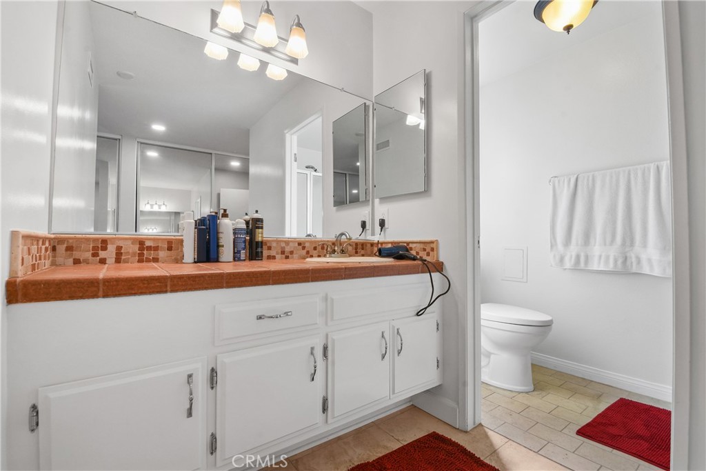 13092 Ranchwood Road Tustin, CA 92782 - Photo 14 of 17 a bathroom with a toilet a sink and a mirror