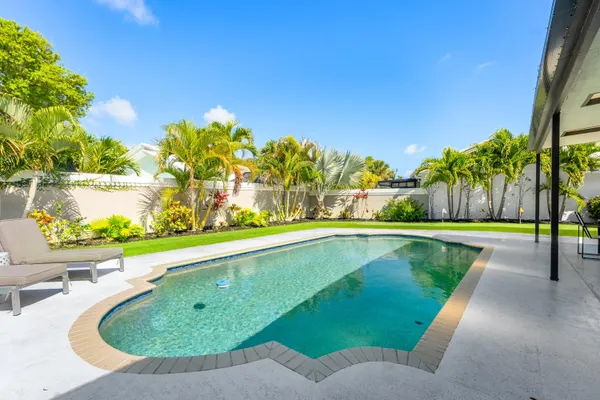 an aerial view of a house with a yard swimming pool and outdoor seating